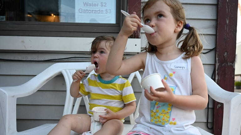 Elijah Elliott-Negri, 2, and sister Samaya, 4, eat ice cream...