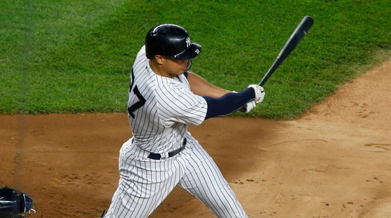 Yankees' Giancarlo Stanton follows through on a third-inning two-run double...