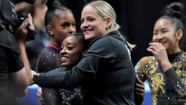 Simone Biles gets a hug from her coach, Cecile Landi,...