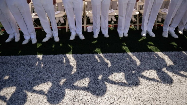 Midshipmen salute during the ceremony as more than 220 future...