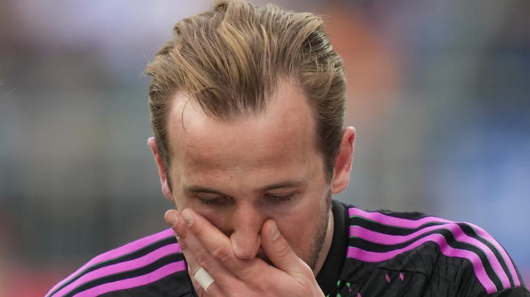 Bayern's Harry Kane reacts after he was injured during a...