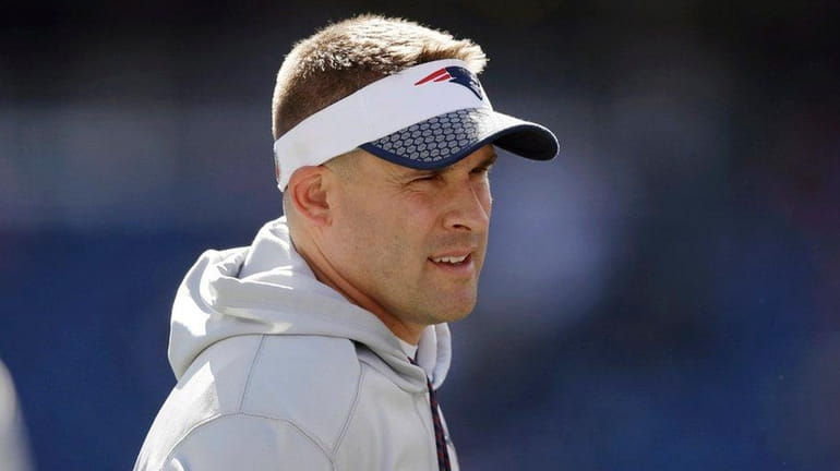 Patriots offensive coordinator Josh McDaniels, left, speaks to head coach...