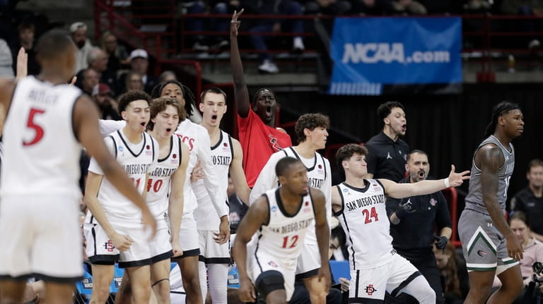 The San Diego State bench celebrates a basket by guard...