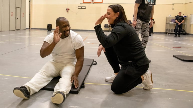 Inmate LaJuan Kelly, of Hicksville, left, high-fives CrossFit instructor Melissa...