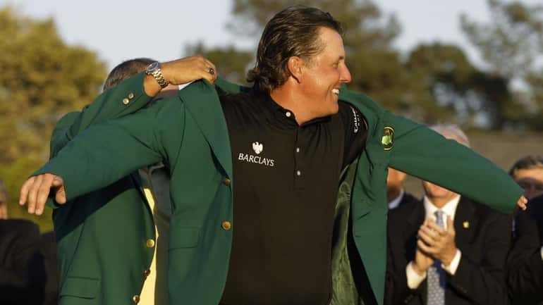 Phil Mickelson puts on the Masters jacket after winning the...