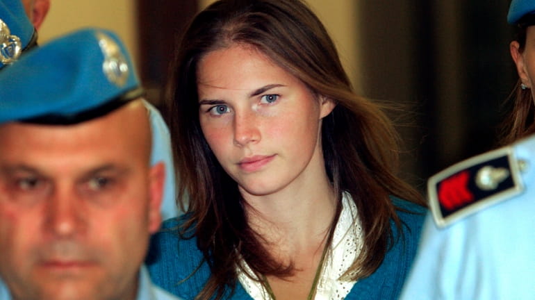 In this Sept. 26, 2008 Amanda Knox, center, is escorted...