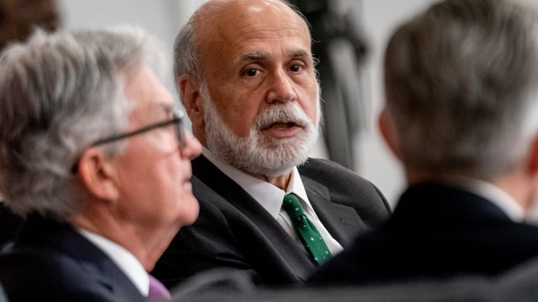 Former Federal Reserve Chairman Ben Bernanke, center, accompanied by Federal...