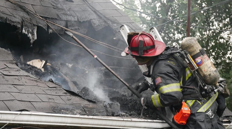 A firefighter battles a blaze at a home on Magnolia...