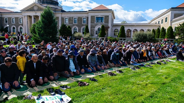 Members of the Muslim community pray on the lawn in...