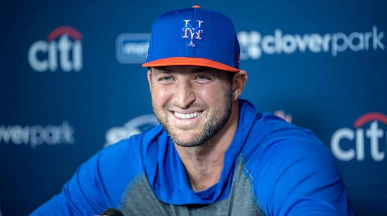 The Mets' Tim Tebow talks to the media during a...
