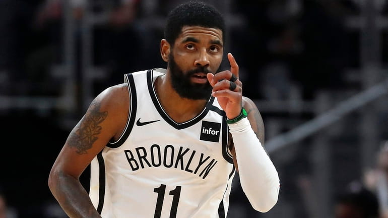 Nets guard Kyrie Irving reacts after a basket in overtime of...