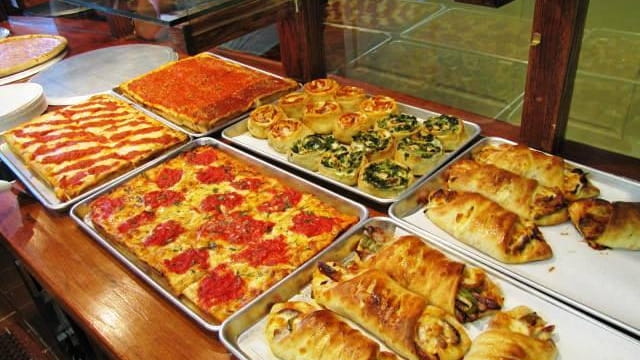 Pies, rolls and calzones behind the counter of Green Olive...