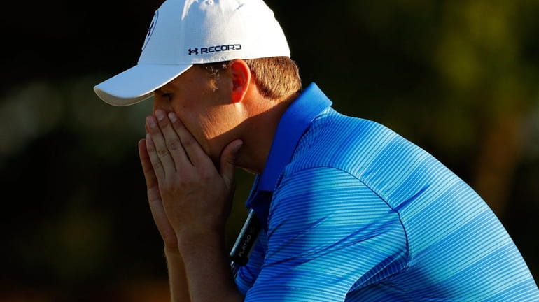 Jordan Spieth reacts after finishing on the 18th green during...