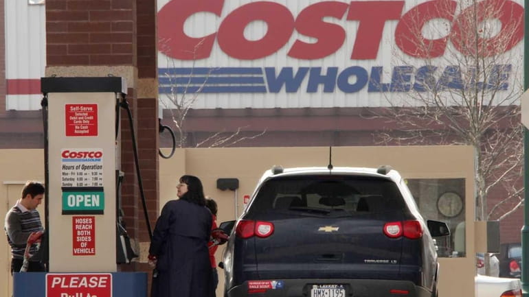Costco members pump gas outside a Costco Wholesale store in...