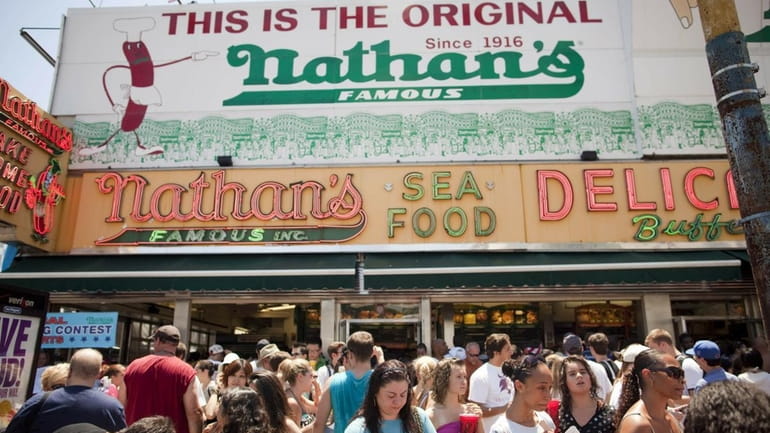 People crowd outside of the original Nathan's Famous after the...