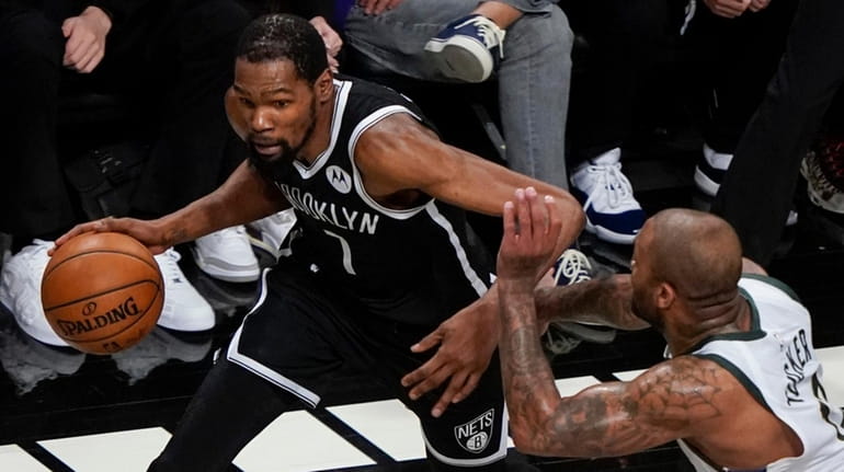 The Nets' Kevin Durant, left, drives past the Bucks' P.J....