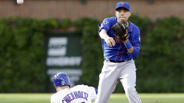 Mets second baseman Wilmer Flores throws to first base during...