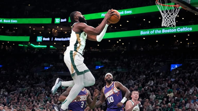 Boston Celtics guard Jaylen Brown (7) drives to the basket...
