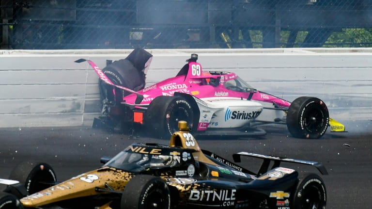 Simon Pagenaud, of France, hits the wall in the third...
