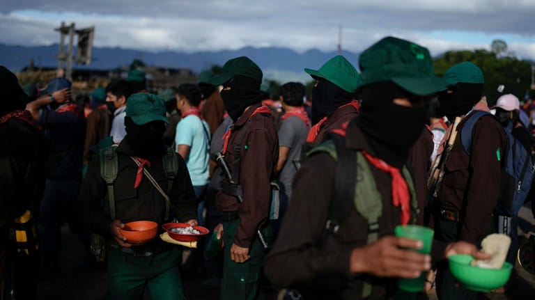 Members of the Zapatista National Liberation Army hold meals during...