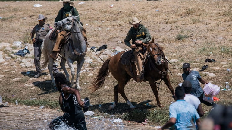 Customs and Border Protection mounted officers try to contain migrants...