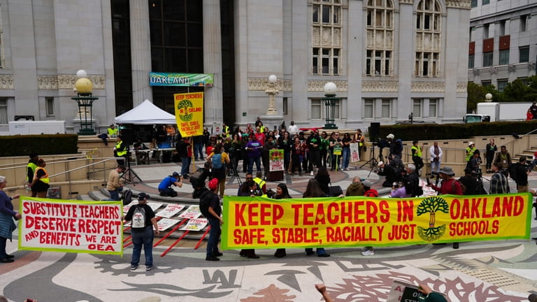 Striking teachers hold a rally outside City Hall in Oakland,...