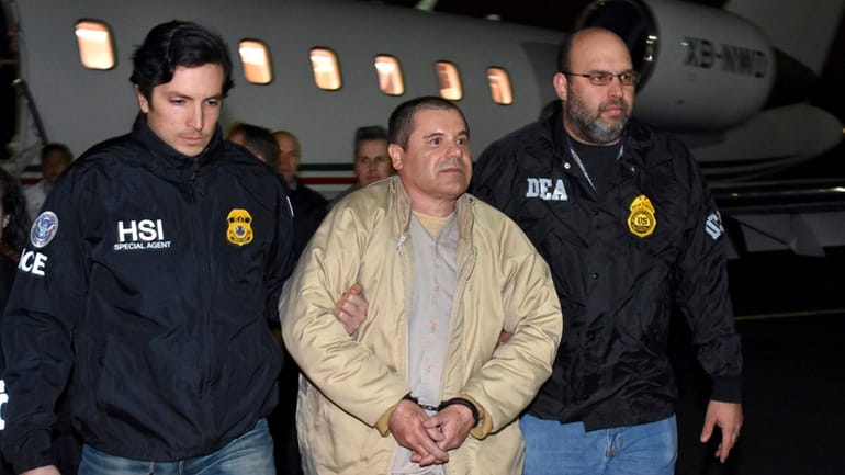 Authorities escort Joaquin "El Chapo" Guzman from a plane to...
