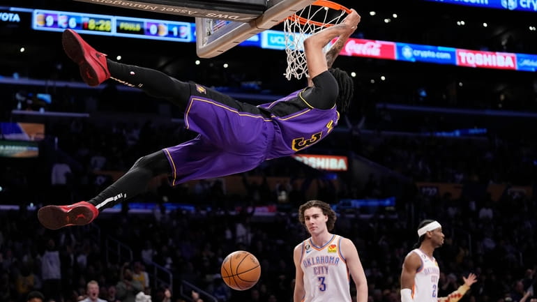 Los Angeles Lakers forward Anthony Davis, top, dunks as Oklahoma...