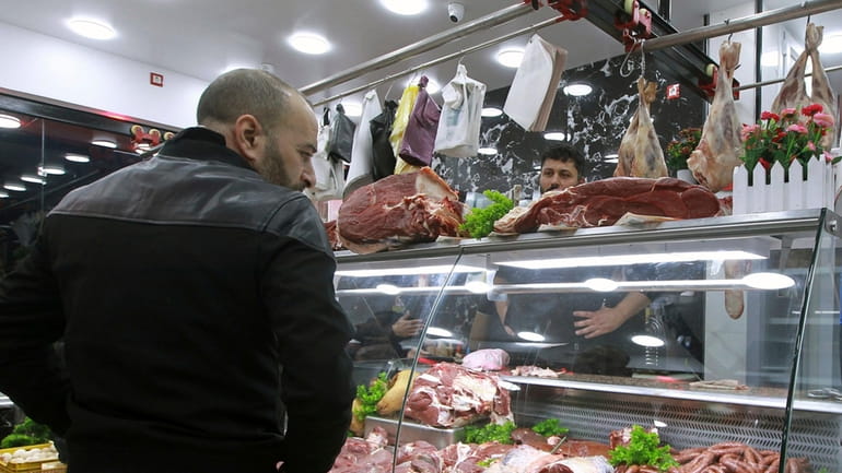 People shop for beef at a butchery in Algiers, Algeria,...