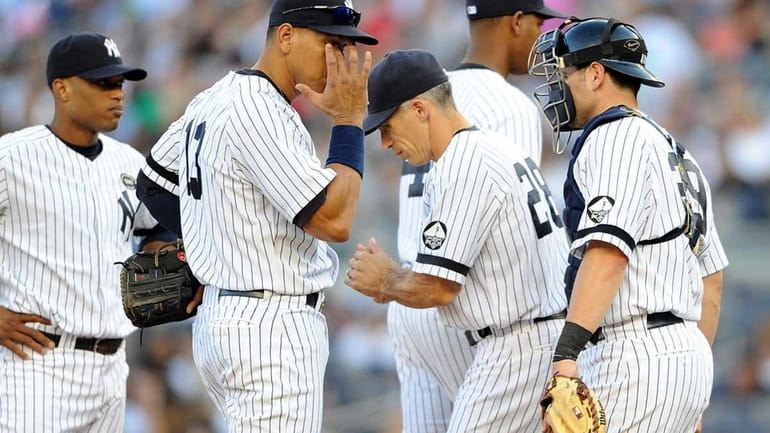 New York Yankees manger Joe Girardi, center, makes a trip...