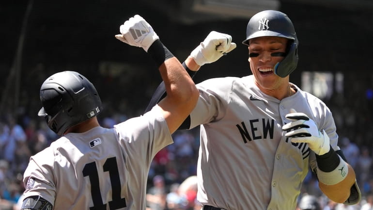 Yankees' Aaron Judge celebrates with Anthony Volpe (11) after hitting...
