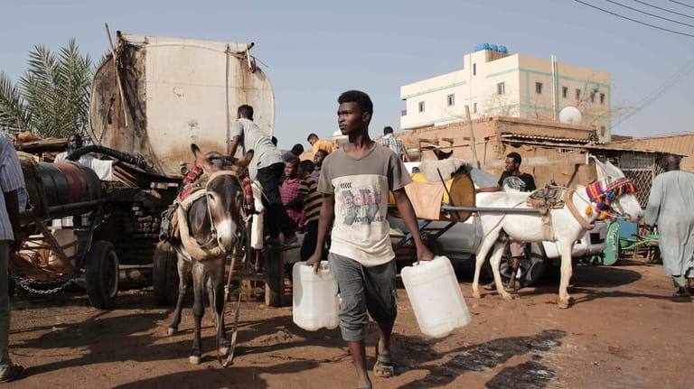People gather to collect water in Khartoum, Sudan, Sunday, May...
