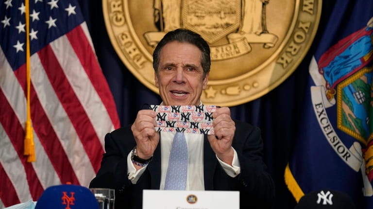 New York Governor Andrew Cuomo shows off a mask that...