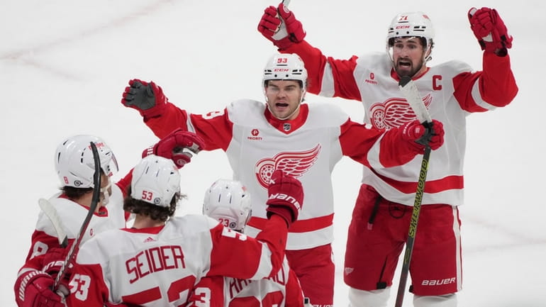 Detroit Red Wings' Moritz Seider (53) celebrates with teammates after...