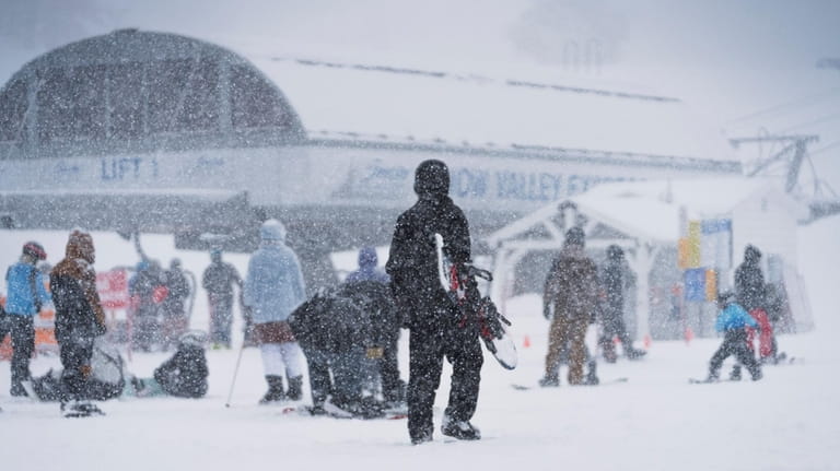 Snow falls on snowboarders and skiers on the Big Mountain...