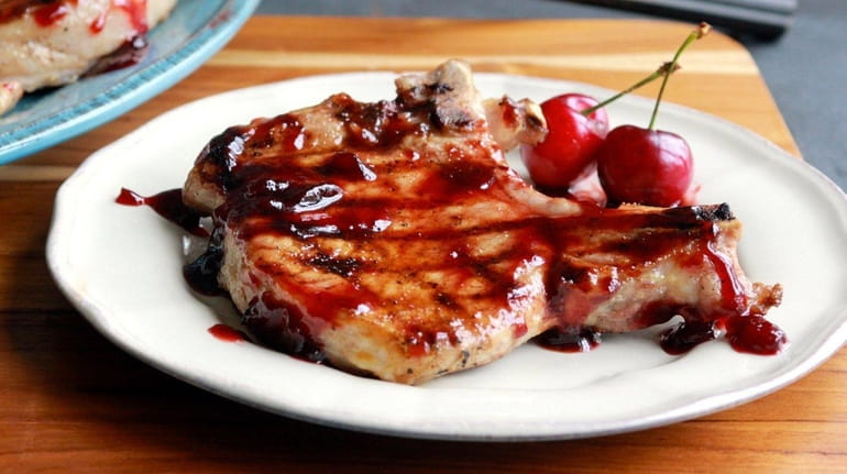 Grilled pork chops with cherry-sriracha sauce.