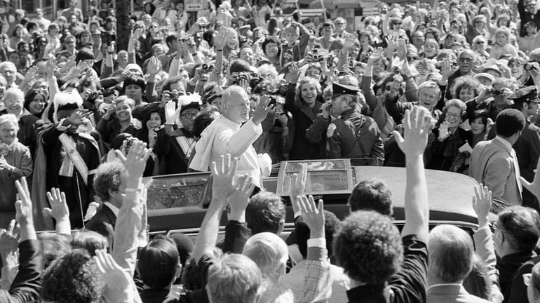 Pope John Paul II responds to the enthusiastic crowd outside...