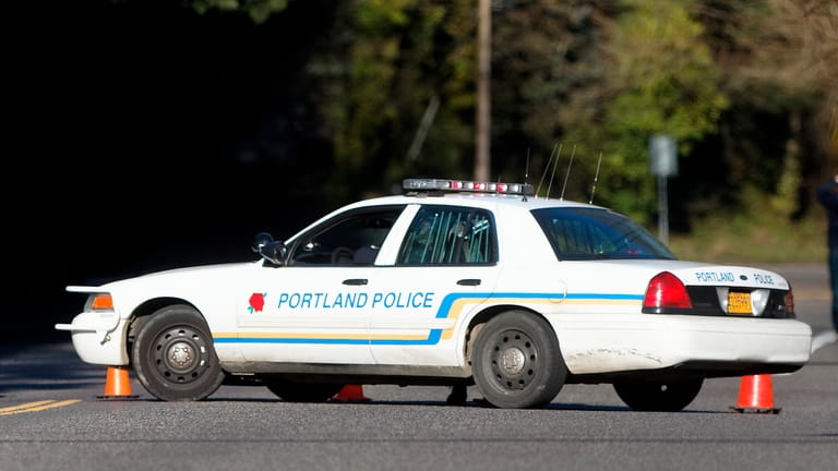 A Portland police vehicle is parked at a crime scene...