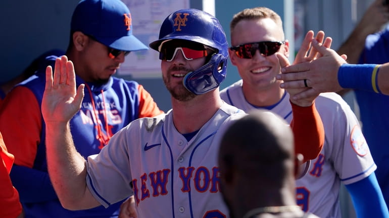 The Mets' Pete Alonso is congratulated by teammates in the...