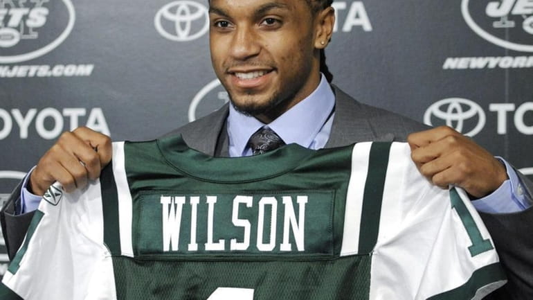 Kyle Wilson holds up a Jets jersey after the team...