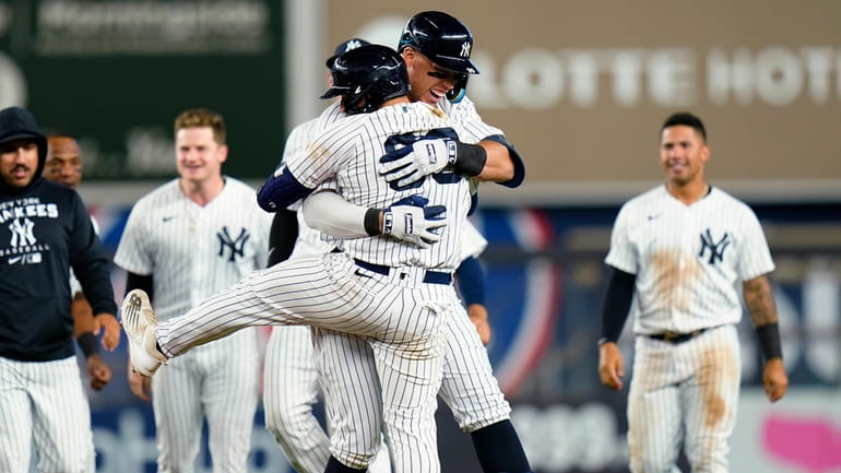 Yankees' Aaron Judge hugs Jose Trevino, front, after Trevino hit...