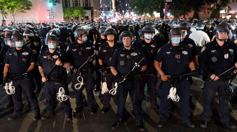 NYPD officers prepare to detain demonstrators on Fifth Avenue in...
