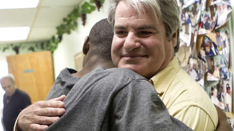 Volunteer Brian Abramowitz receives a hug from one of the...