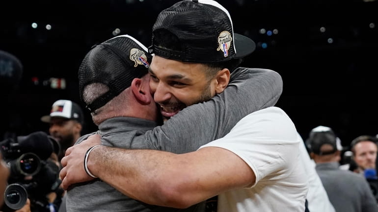 Denver Nuggets guard Jamal Murray, right, is hugged by head...