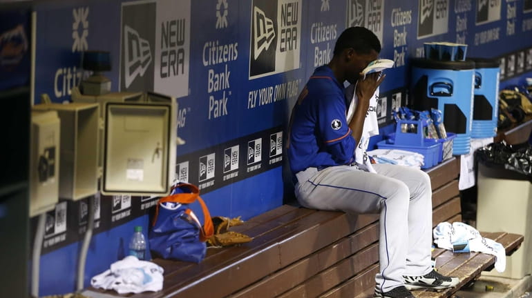 Mets starting pitcher Rafael Montero wipes his face on the...