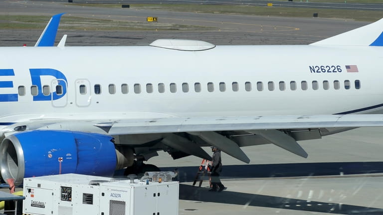 A Medford Jet Center worker walks under a United Boeing...
