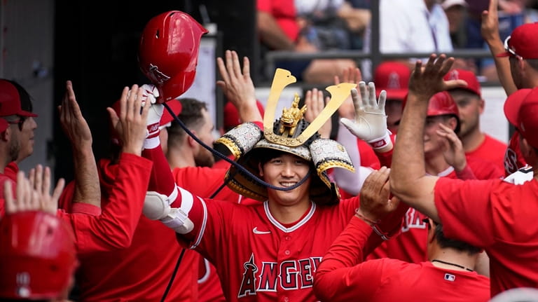 Los Angeles Angels' Shohei Ohtani celebrates in the dugout his...
