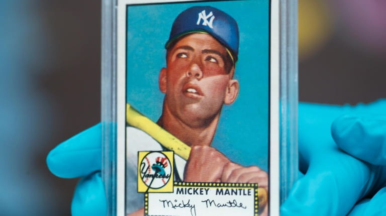 A  "Mint 9" 1952 Topps Mickey Mantle card sold in...