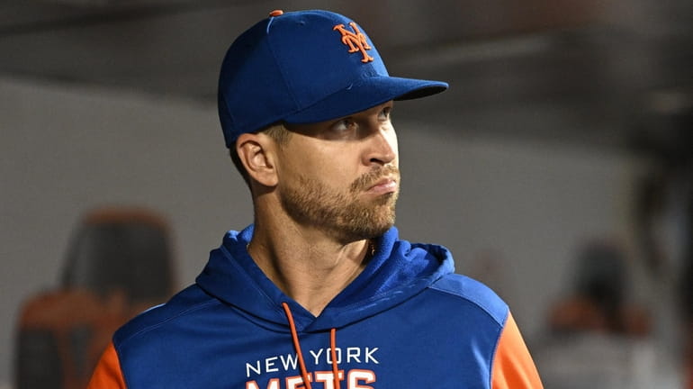 Mets pitcher Jacob deGrom looks on from the dugout against...