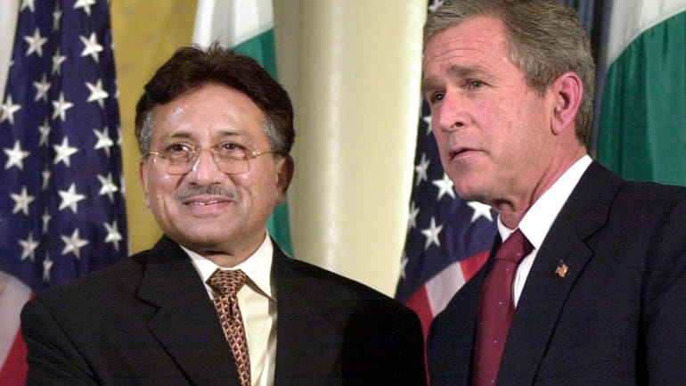 Then-U.S. President George W. Bush, right, shakes hands with then-Pakistani...